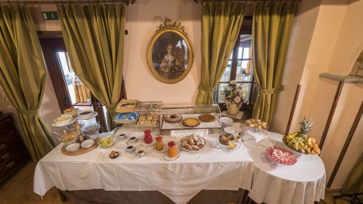 Ein Tisch mit Süßigkeiten, Früchten und Getränken in einer gemütlichen Umgebung.