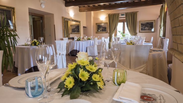 Einfache Essbereich mit gedeckten Tischen und Blumendekorationen in einer entspannten Umgebung.