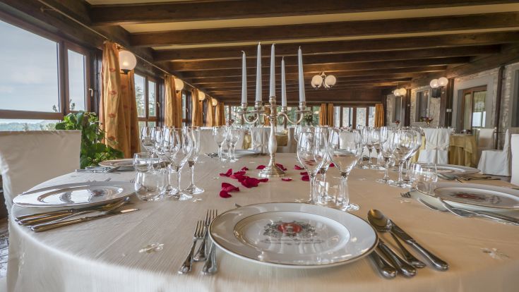 Ein wunderschön gedeckter Tisch mit einem Kerzenhalter und Rosenblättern, ideal für ein besonderes Abendessen.