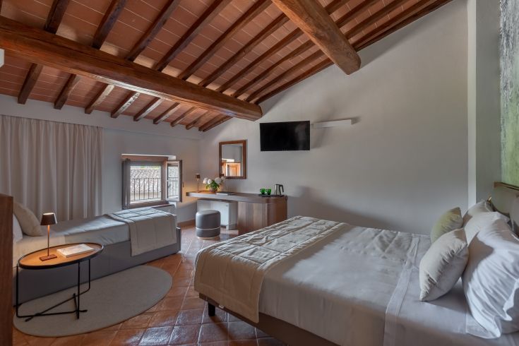 Heller Raum mit sichtbaren Balken und schlichter Einrichtung, ideal für einen ruhigen Aufenthalt.