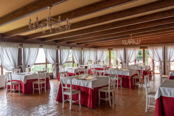 Ein einladendes Restaurant mit gut angeordneten Tischen, leichten Vorhängen und einer ruhigen Atmosphäre. Perfekt für angenehme Abendessen.