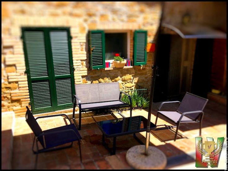 Scena pacifica in un palazzo ristrutturato, immerso nella natura tipica dell'Umbria.