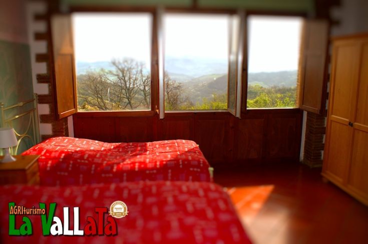 Camera con panorama sulle colline umbre, dotata di due letti e un'atmosfera tranquilla e accogliente.