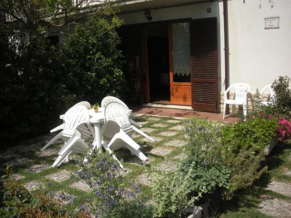 Outdoor area of Agriturismo Le Rose in Castiglione del Lago, surrounded by nature, trees, and gardens.