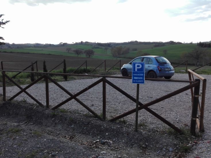 A parking area located among hills, surrounded by greenery, perfect for agriturismo.