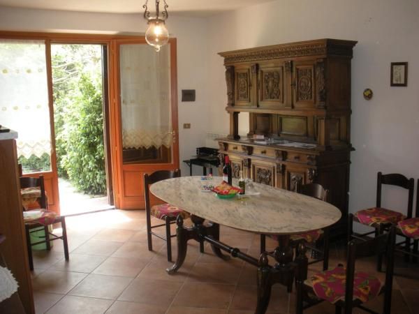 A simple agriturismo space featuring a wooden table and light-colored furnishings.