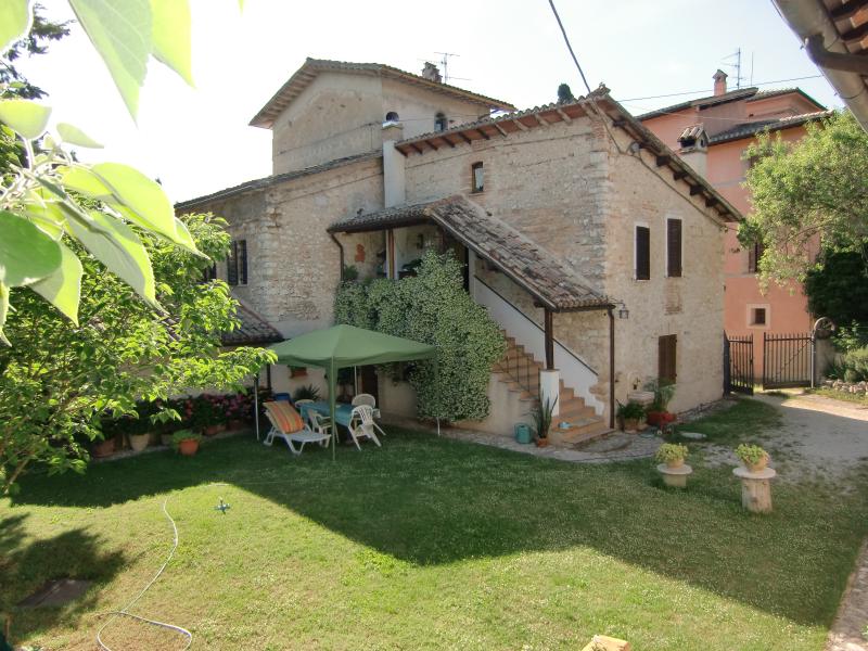 Un casale in pietra del 1600 situato in una zona verde dell'Umbria, immerso nel paesaggio naturale circostante.