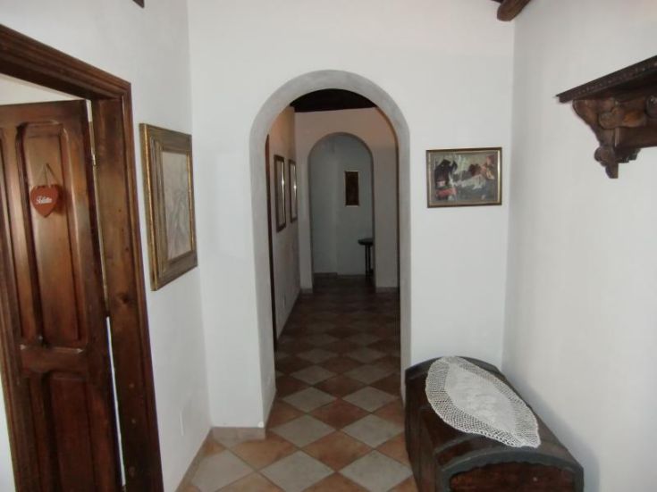 Un couloir d'un bâtiment avec des éléments architecturaux simples et des décorations murales aux tons neutres.