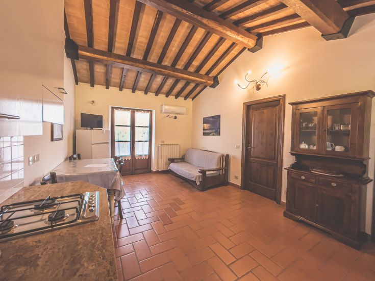 Ampio appartamento caratterizzato da travi a vista, con cucina funzionale e una zona soggiorno comoda.