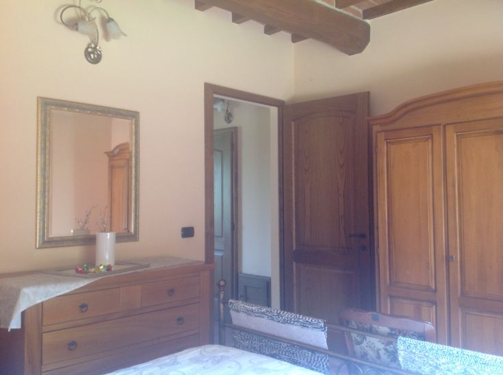 Camera semplice con mobili in legno e elementi rustici, adatta per un soggiorno tranquillo.