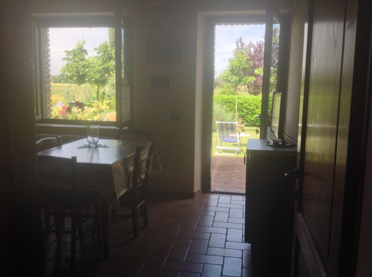 Interno di un agriturismo con un piacevole panorama su un giardino curato, ideale per momenti di relax.
