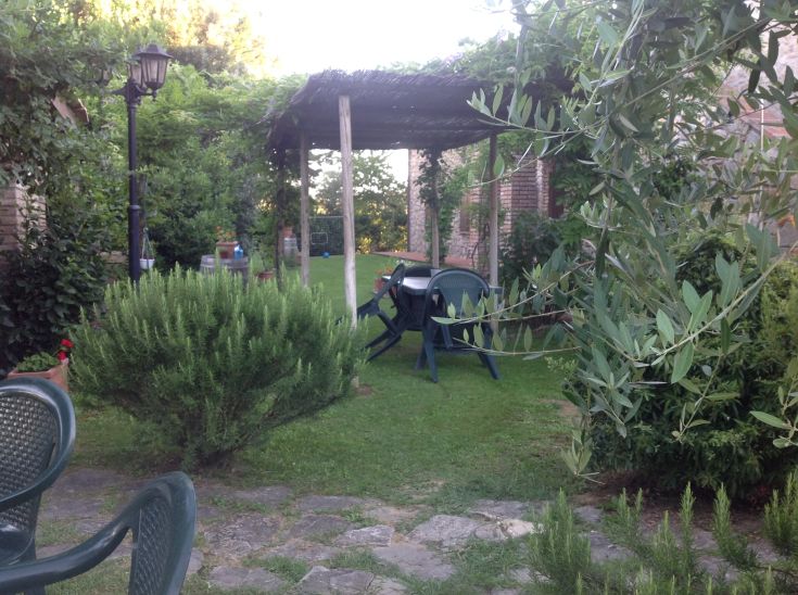 Un'area tranquilla all'interno del giardino dell'agriturismo, con prati e panchine per il relax.