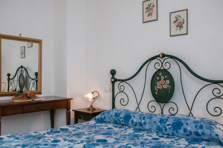 Cozy room featuring a simple bed with floral details. A perfect space for a peaceful stay.