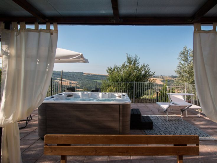 Relaxing panorama with a jacuzzi set in the lush green hills of Umbria.