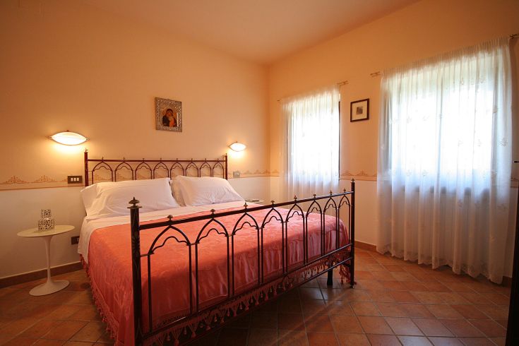 Camera tranquilla con letto matrimoniale e semplici decorazioni. Spazio adatto per un soggiorno comodo.