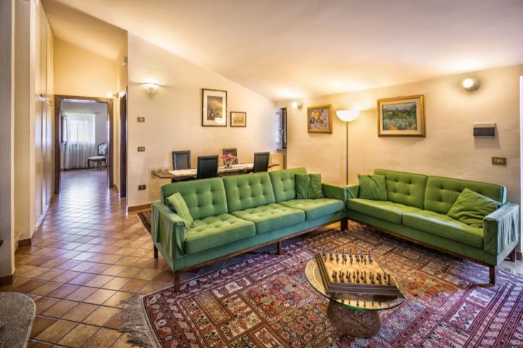 Soggiorno confortevole con divani verdi e tappeto, adatto per momenti di quiete e relax.