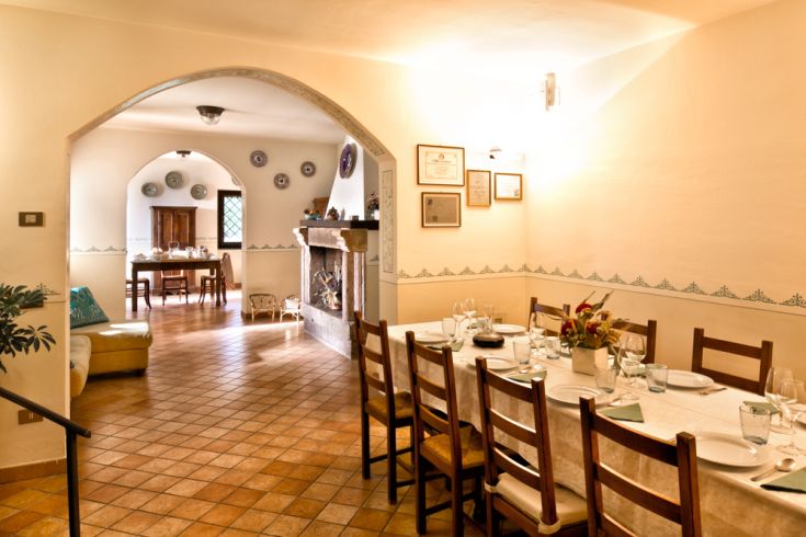 Spazio informale per i pasti, con tavolo e sedie in legno, adatto per momenti conviviali.