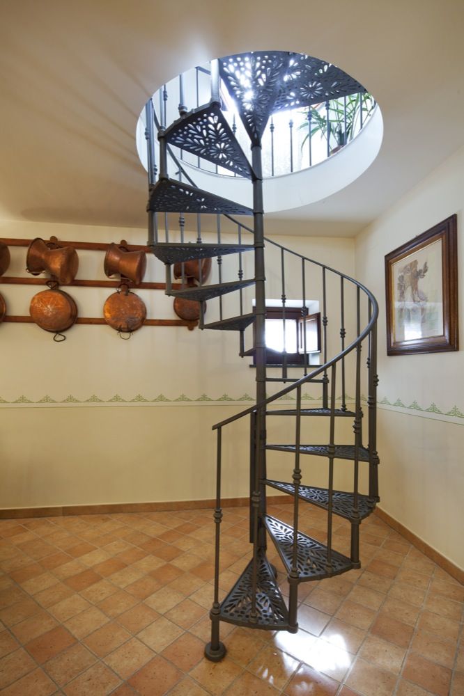 Scalinata a chiocciola in ferro, semplice e luminosa, adatta a un'atmosfera familiare.