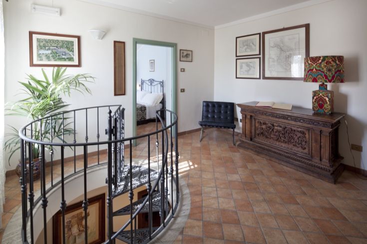 Accesso al palazzo Rosy, con una scala a chiocciola e decorazioni semplici. Ambiente sobrio.