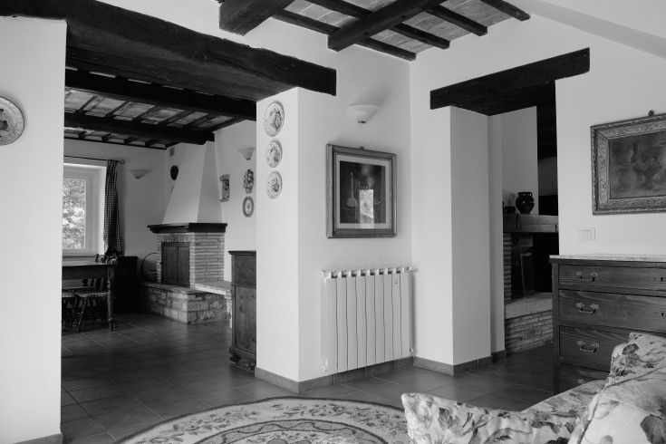 Interior of a building featuring rustic details, a fireplace, simply and functionally furnished.