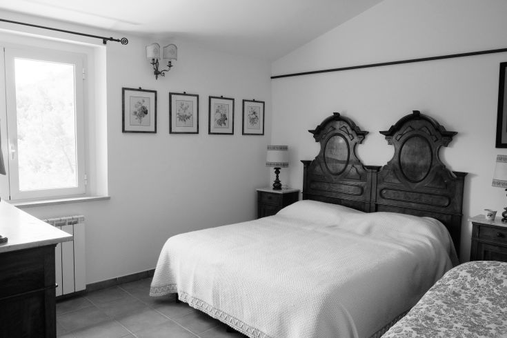 Simple and bright bedroom with traditional furniture elements and wooden finishes.