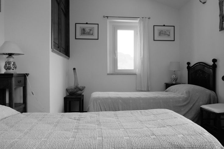 Room in an old building featuring separate beds and simple decorations.