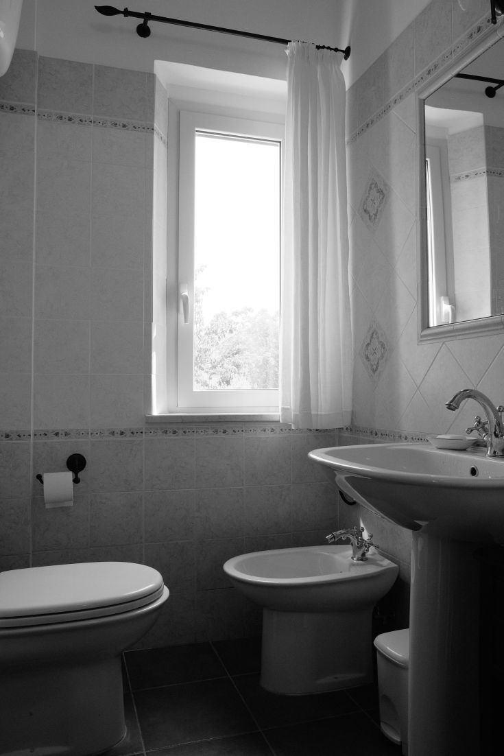 A simple bathroom with a window that brightens the space, furnished in a minimalist style.