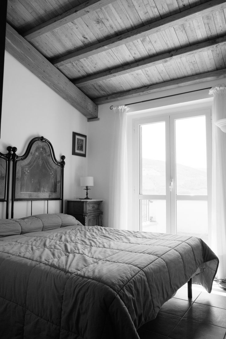 Cozy room with a double bed and large windows that allow ample natural light.