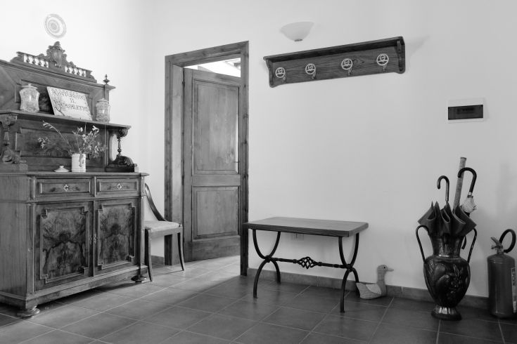 A simple entrance featuring a wooden piece, umbrellas, and rustic details.