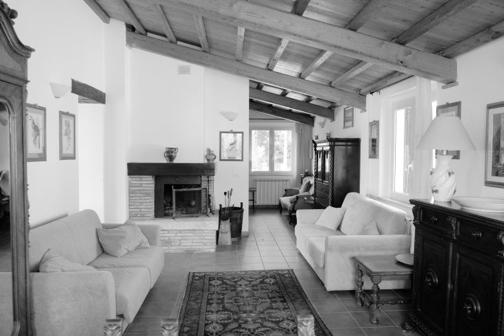 A simple living room with exposed beams and dark wooden furniture.