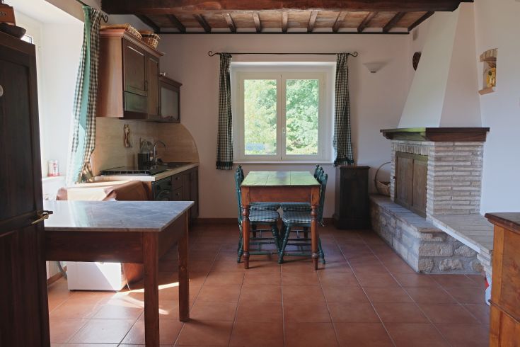 Traditional kitchen with wooden details and a view of olive groves. A perfect space for spending time together.