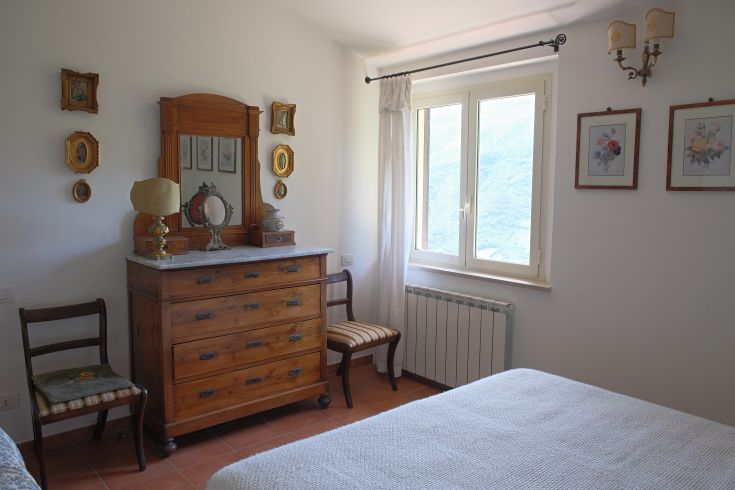 Cozy vintage camera with wooden furniture and a relaxing view of the Umbrian hills.