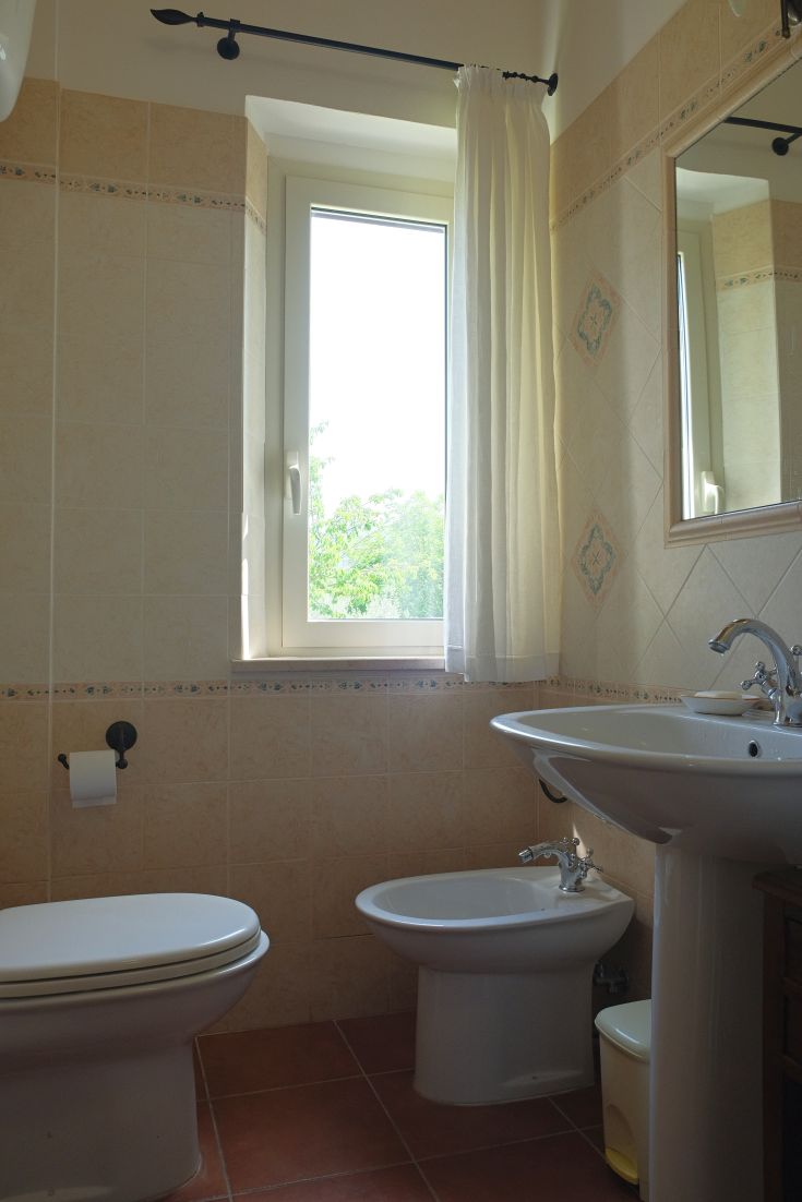 A simple and bright bathroom with a window providing natural light. Modern and minimalist decor.