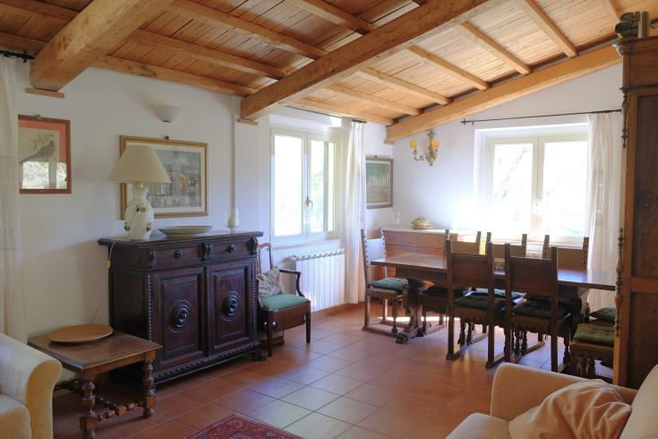 Cozy interior of a farmhouse with wooden ceilings, vintage furniture, and a view of the surrounding countryside.