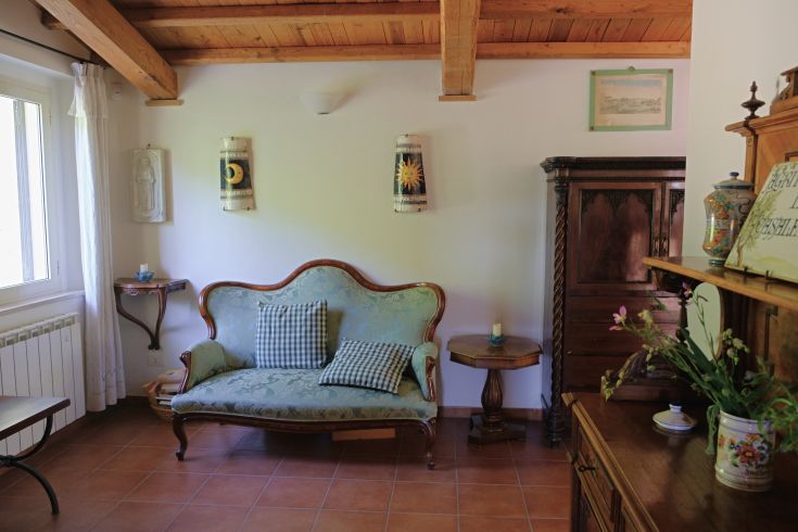 A simple living room with traditional furniture and rustic details, creating a calm atmosphere.