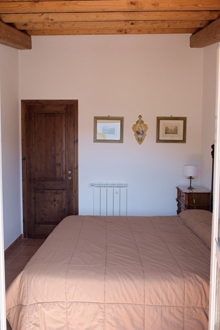 Simple bedroom with a double bed, light wood furniture, and understated decorations.