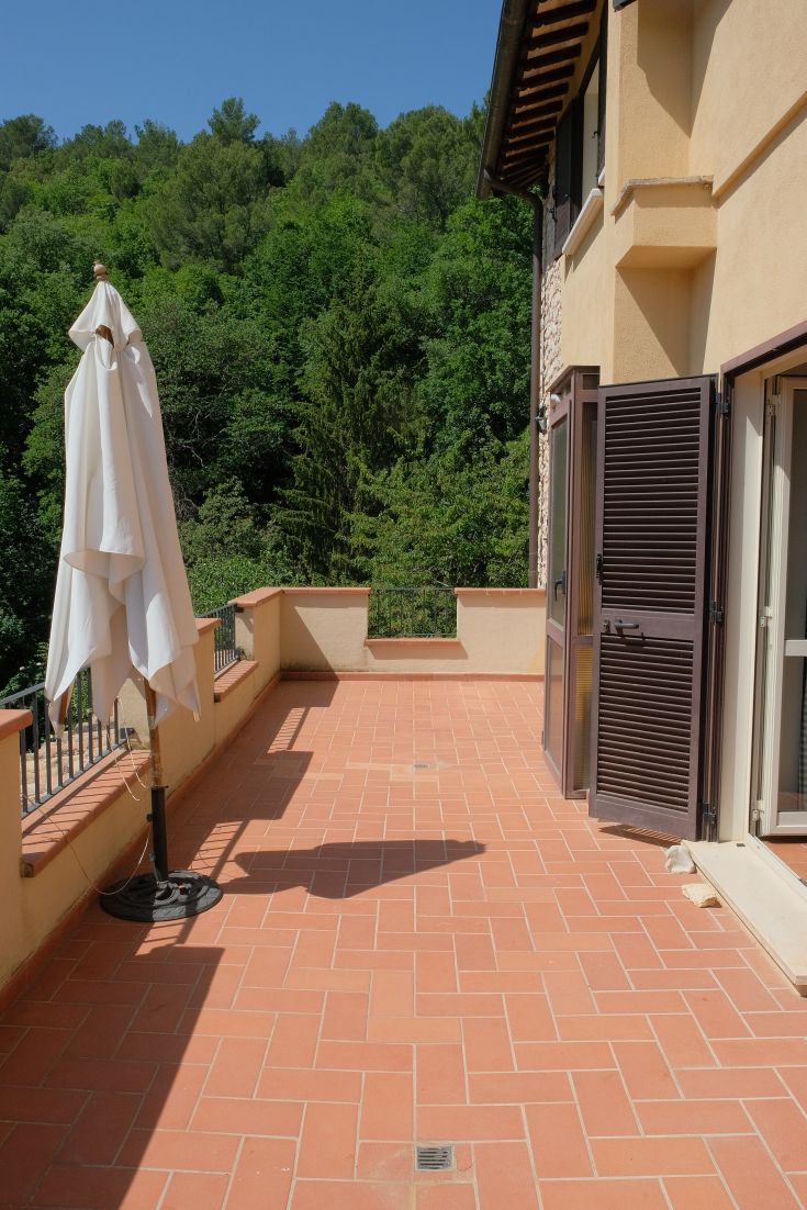 A bright terrace surrounded by greenery, perfect for relaxing outdoor moments.