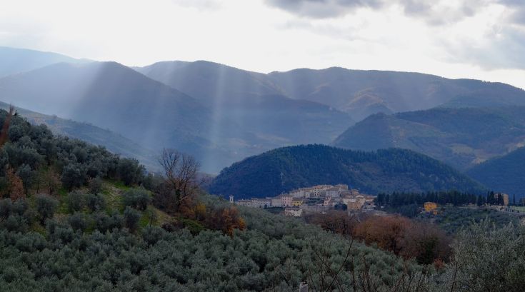 Panorama of Valnerina in Umbria, featuring lush green hills and olive groves spreading across the landscape.