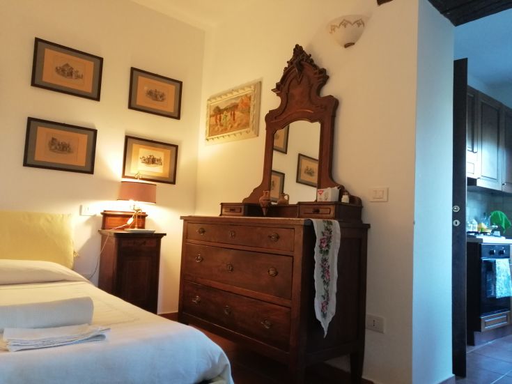 A simple bedroom featuring wooden furniture and subtle decor, perfect for relaxation.