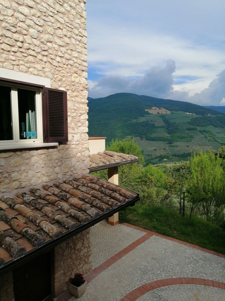 A renovated stone farmhouse surrounded by olive groves and forests. A tranquil scene of the Valnerina.