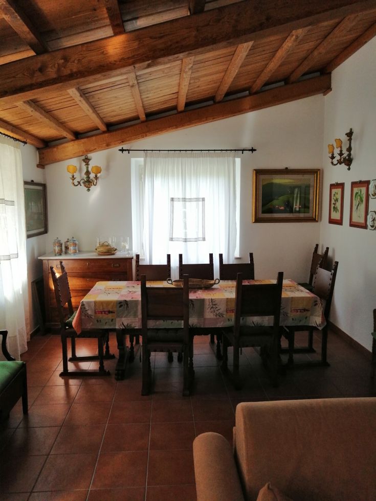 Cozy interior of a farmhouse with a long wooden table, ideal for sharing meals with friends.