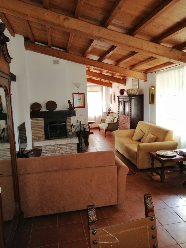 Cozy interior with exposed beams and a fireplace, featuring wooden furniture, perfect for relaxation moments.