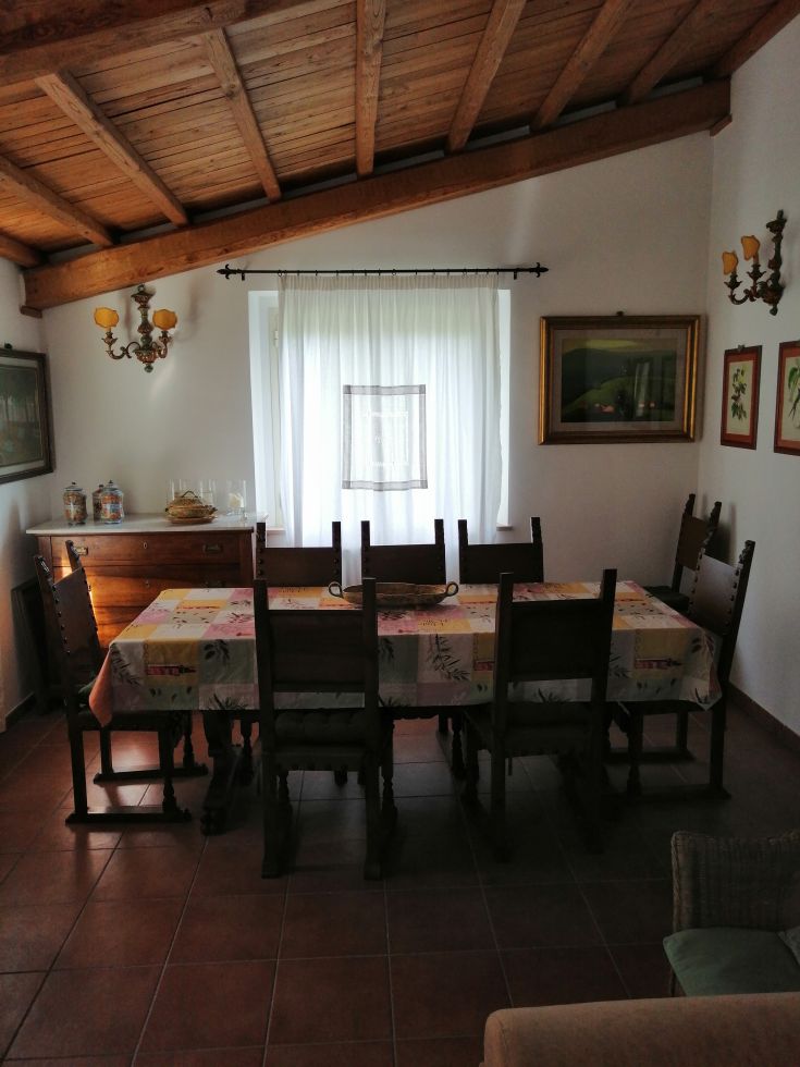 Casual dining area featuring a wooden table and chairs, softly lit.