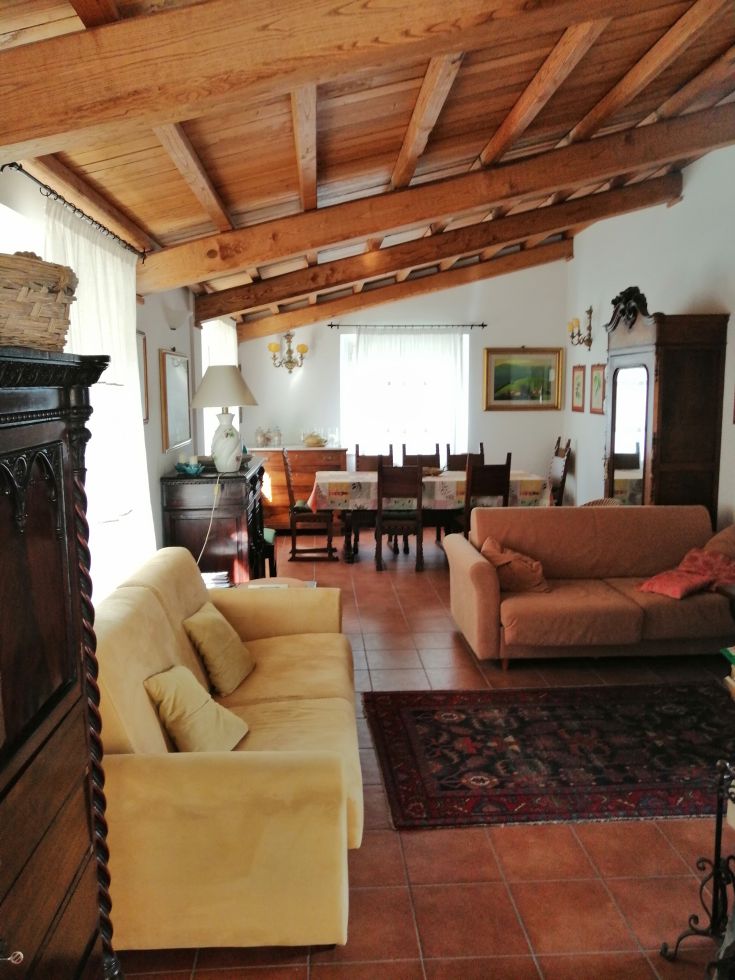 A cozy living room with wooden beams and traditional furnishings, creating a homely atmosphere.