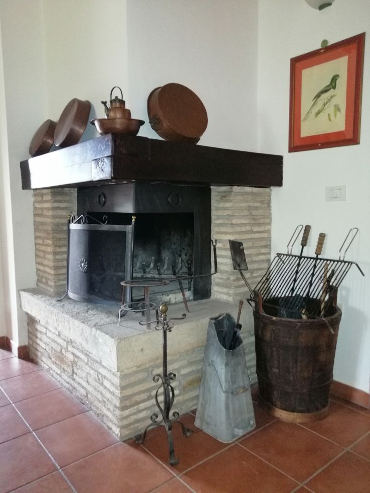 A serene environment with a fireplace, traditional tools, and simple decorations creating a cozy atmosphere.