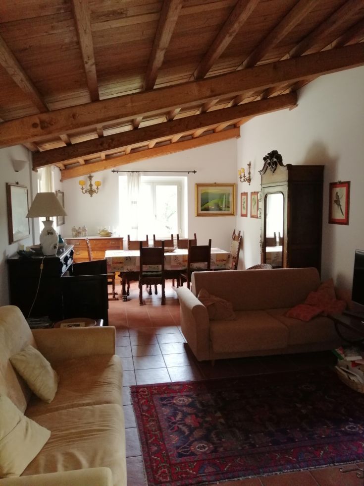 A cozy living room with exposed beams and simple furnishings, perfect for relaxation moments.