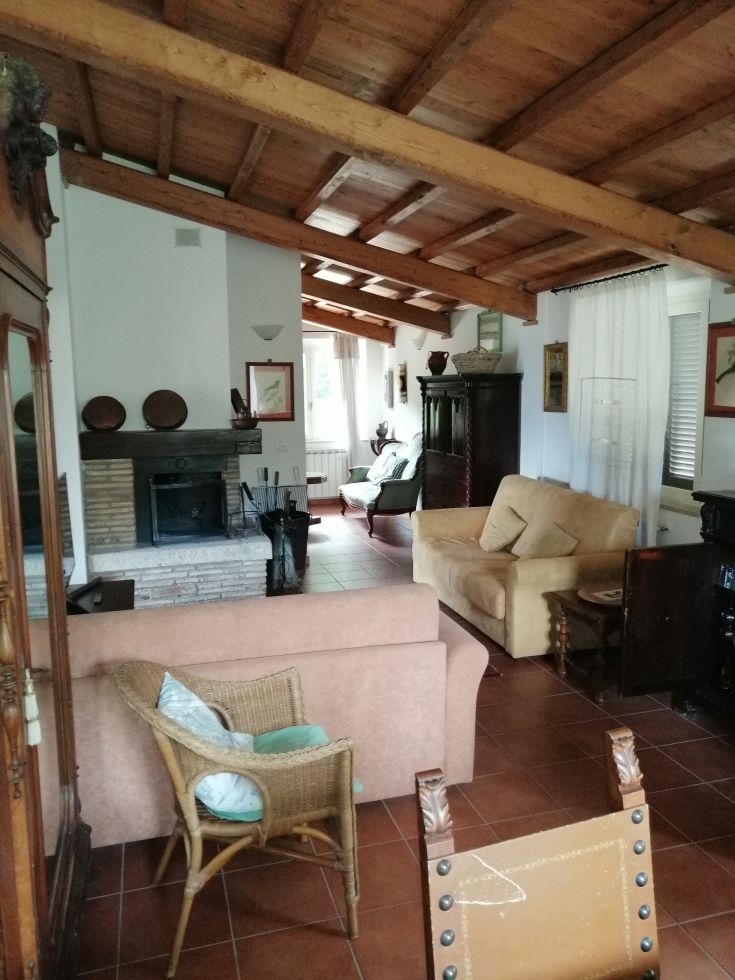 A cozy living room with exposed beams and wooden furniture, creating a warm and family-friendly atmosphere.