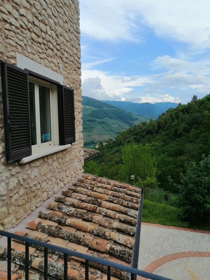 A restored stone farmhouse nestled among olive groves and woods in Valnerina.