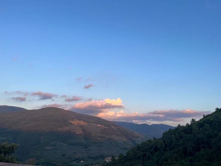 A view of the Umbrian hills under a clear sky with light clouds enhancing the landscape.