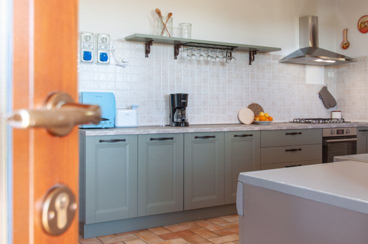 Cucina moderna e funzionale, arredata con mobili in legno e attrezzature complete per la preparazione dei pasti.